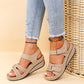 Beige wedge sandals with velcro straps worn with anklets and frayed hem jeans